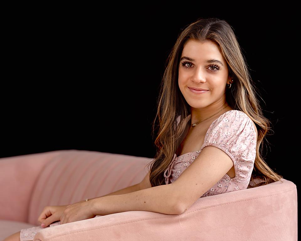senior in pink dress on pink couch