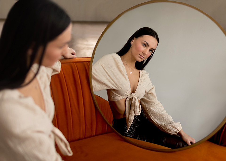 senior model looking in mirror at her own reflection

