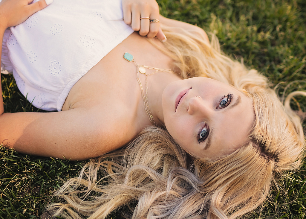 senior portrait of girl laying in grass 